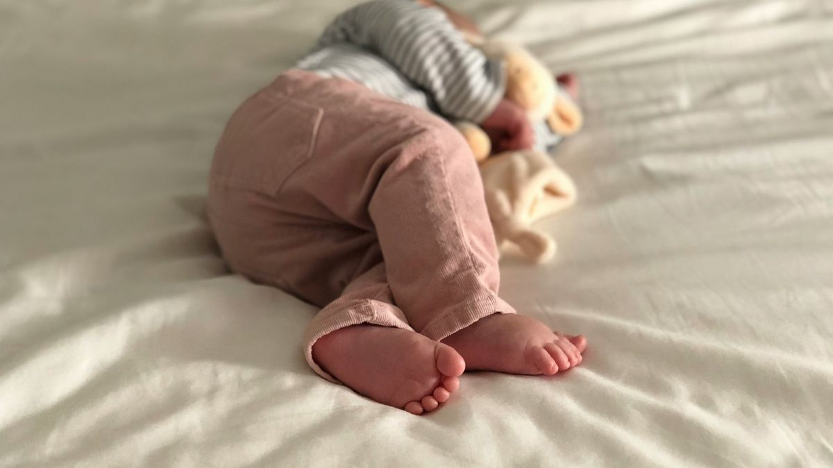 Little girl sleeping in bed with a stuffed animal