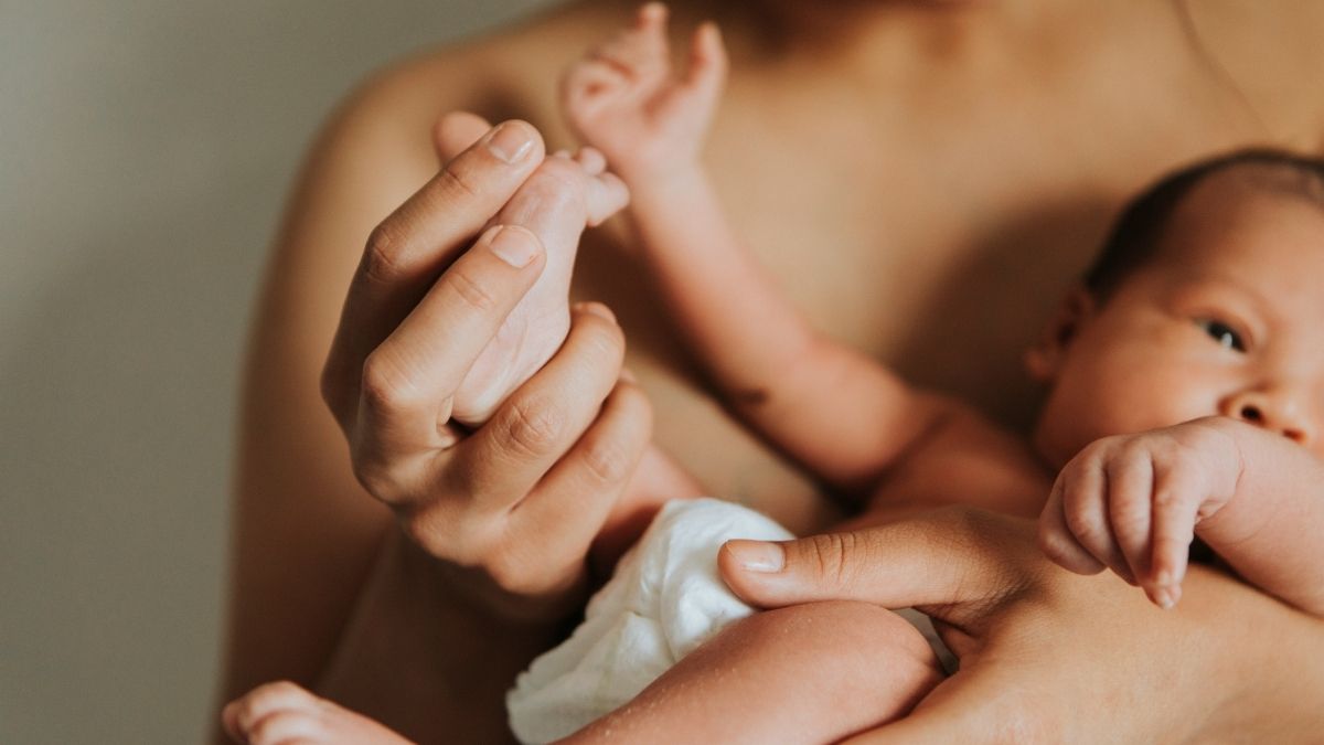 Mother holding newborns feet